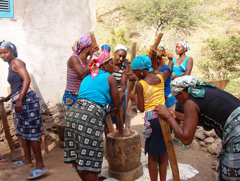 Frauen stampfen Mais in einem pilao