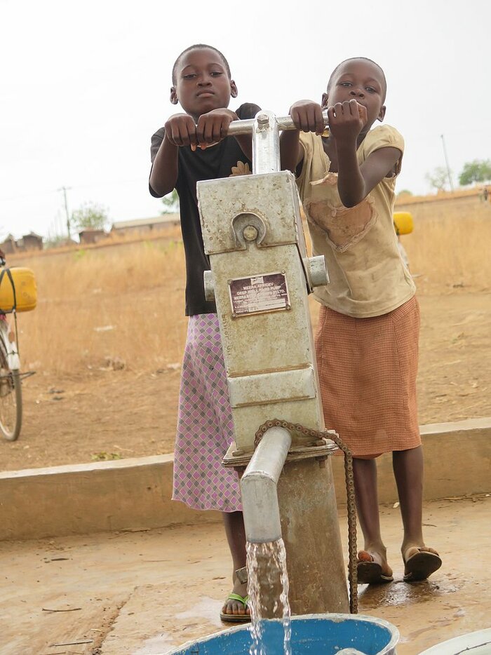 Mädchen pumpen Wasser in Ghana