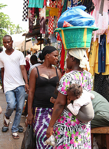 Frau mit Kind auf dem Rücken in Gambia