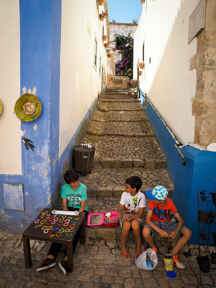 Kinde rbeim Straßenverkauf von Armbändern in Òbidos