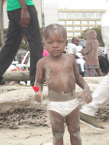 Kind mit Lolli am Strand in Gabun