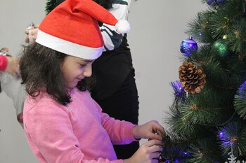 Mädchen schmückt Weihnachtsbaum in Armenien