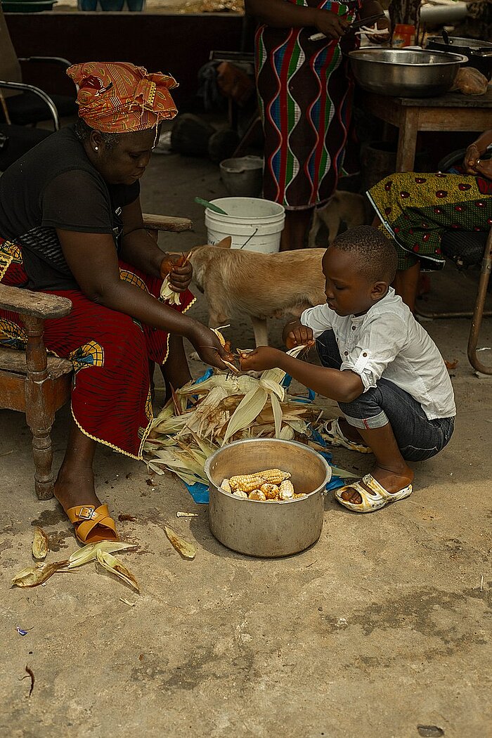 Mutter und Sohn kochen in Liberia Mais