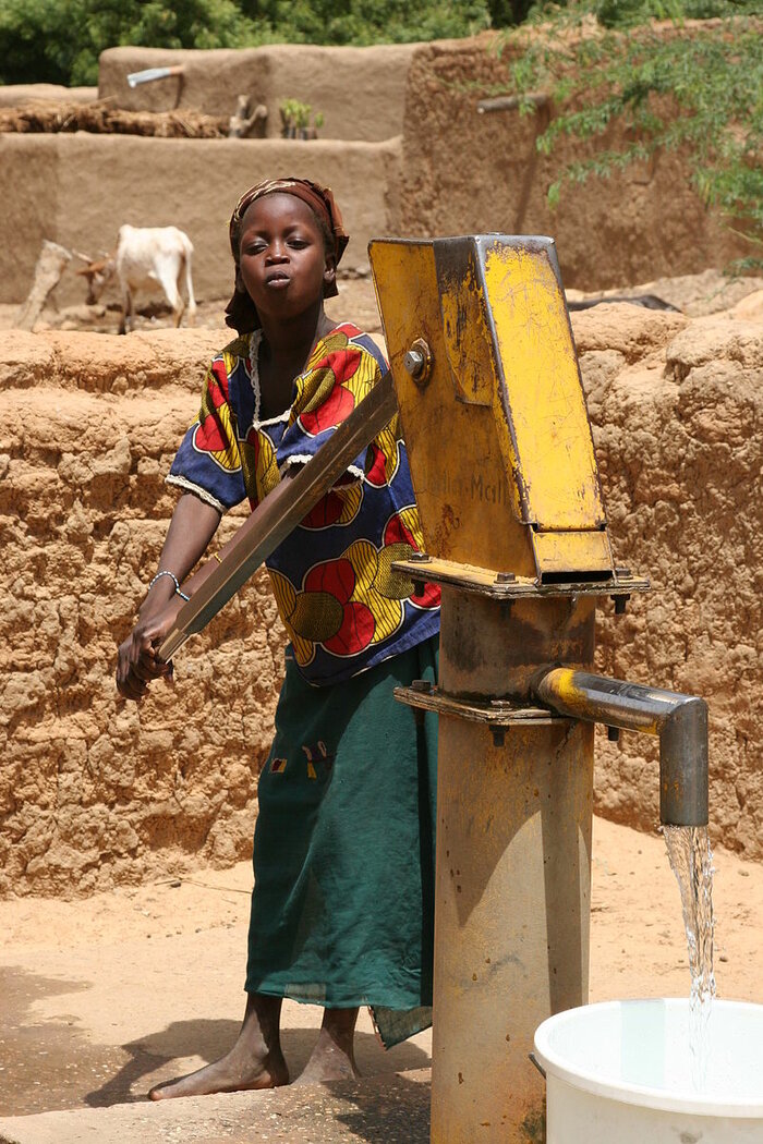 Malisches Mädchen an der Wasserpumpe