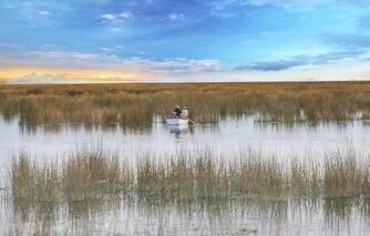 Menschen aus Bolivien in einem Boot im Schilf