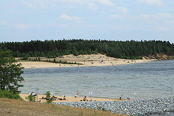 Urlauber*innen und Anwohner*innen lassen es sich am Strand des Bärwalder Sees gut gehen.
