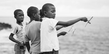 Jungen von São Tomé spielen mit selbst gebastelten Flugzeugen