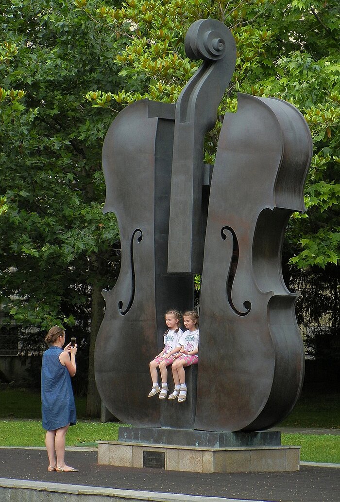 Mutter fotografiert Kinder in Geigen-Denkmal