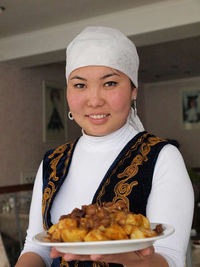 Junge Kirgisin serviert Essen