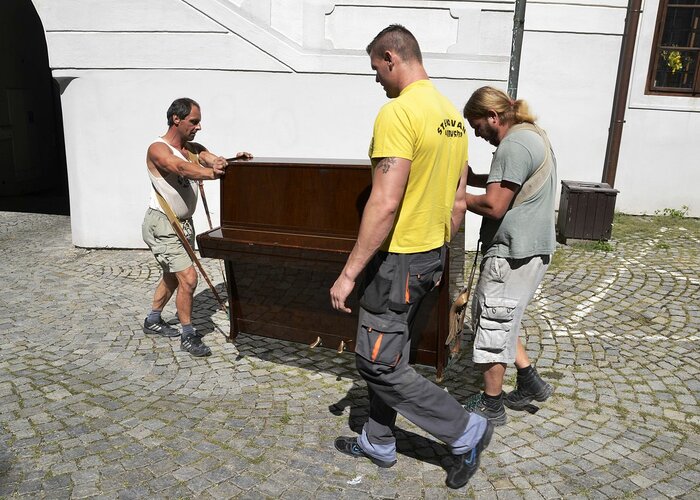 Männer tragen ein Klavier