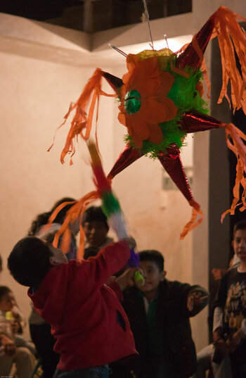 Zerschlagen einer Piñata während einer Posada in Oaxaca