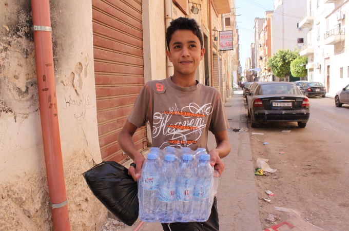 Libyscher Junge mit Wasserflaschen in Bengasi