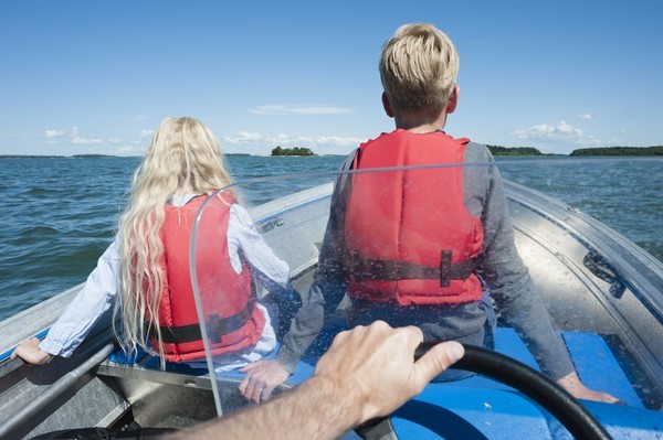 Finnische Kinder fahren im Boot