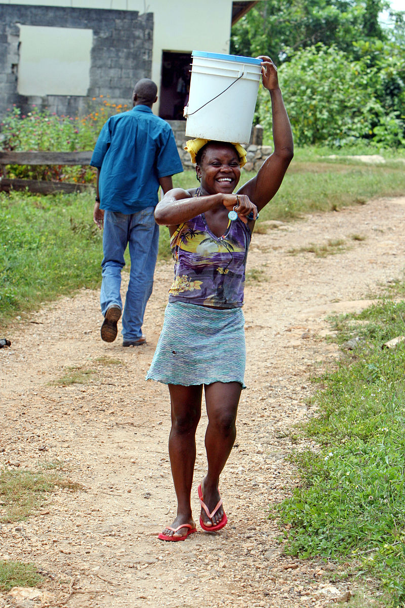 Junge Frau mit Wassereimer in Clarendon, Jamaika